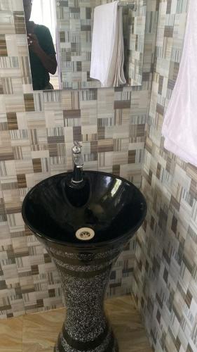 a bathroom with a black sink in a room at Usambara Sunsetview Lodge in Lushoto