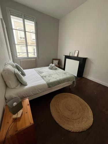 - une chambre avec un lit, une fenêtre et un tapis dans l'établissement Appartment Doutre-2e étage, à Angers