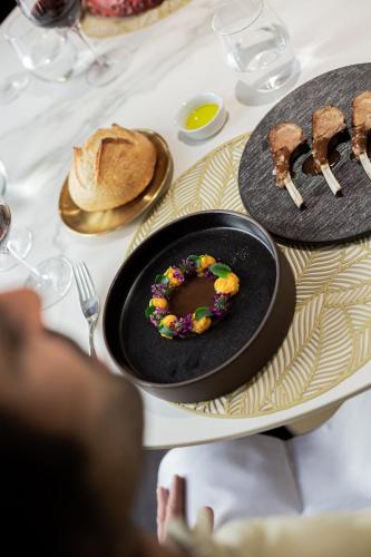 a table with a plate with a donut with sprinkles at Hospes Palau de La Mar, Valencia, a Member of Design Hotels in Valencia