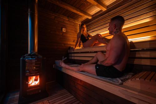 a man and a woman sitting in a sauna at Pohorska Gozdna Vila in Pohorje