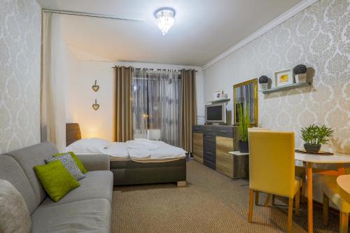 a living room with a couch and a bedroom at Apartmánový dom Fatrapark 1 s Wellness - Hlavná recepcia in Ružomberok