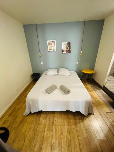 une chambre avec un lit avec deux serviettes dessus dans l'établissement Les loges de la Mairie, à Bourg-lès-Valence