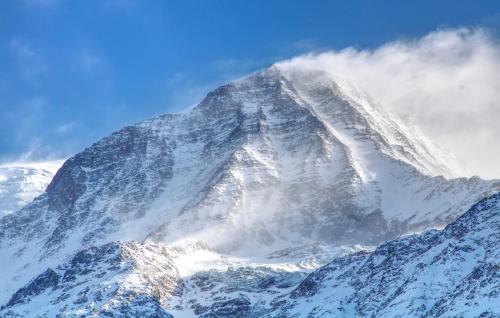 a mountain covered in snow with cloudsigunigunigunigunigunigunigunigunigun at Apartment Aiguille Rose in Les Houches