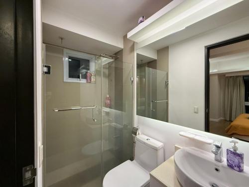 a bathroom with a shower and a toilet and a sink at Modern 1BR Unit in Abreeza Place T2 with Pay Parking in Davao City