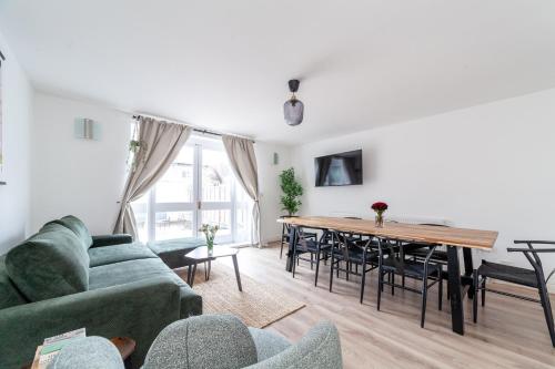 a living room with a green couch and a table at Arte Stays Serviced Houses Stratford - 3 Bedrooms 2 Bathrooms Houses London, Stratford, Maryland, Free Parking, Garden, Weekly or Monthly Stays - up to 8 guests in London