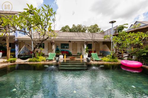 a house with a pond in front of a house at Green BOUTiQUE in Siem Reap