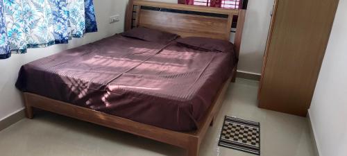 a bed in a room with a wooden frame at "Ambi's stay " A unique and Secluded Nest with serene calmness views on a Traffic-Free Street at Bommasandra 3 km from Narayana Hrudayalaya Hospital in Bangalore