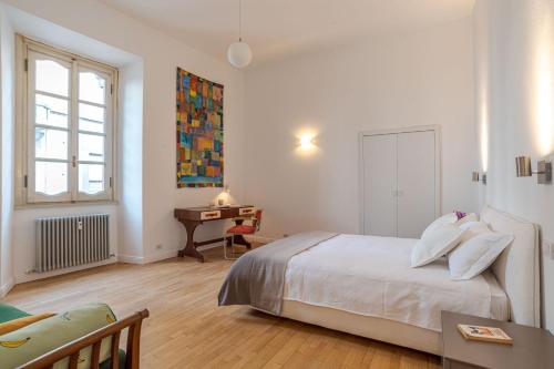 a white bedroom with a bed and a desk at Studio Caspani - Duomo Centro Storico in Como
