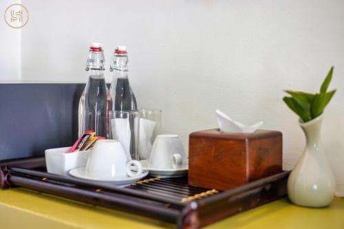 a tray with bottles and cups on a table at Green BOUTiQUE in Siem Reap