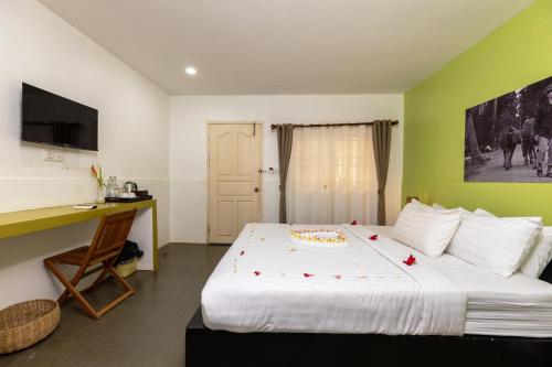 a bedroom with a bed with a cake on it at Green BOUTiQUE in Siem Reap