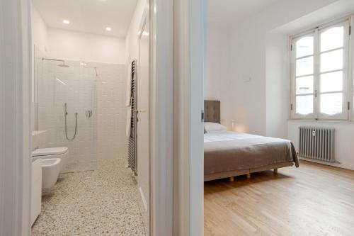a white bathroom with a bed and a shower at Studio Caspani - Duomo Centro Storico in Como
