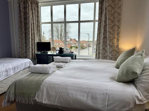 a large white bed in a room with a window at The Crescent York in York