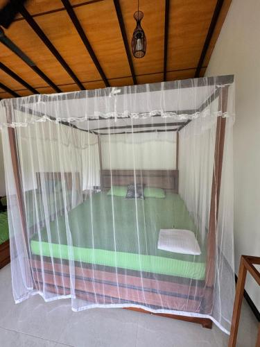 a bed in a tent in a room at Rainforest River Bay in Deniyaya