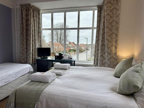 a bedroom with two beds and a large window at The Crescent York in York
