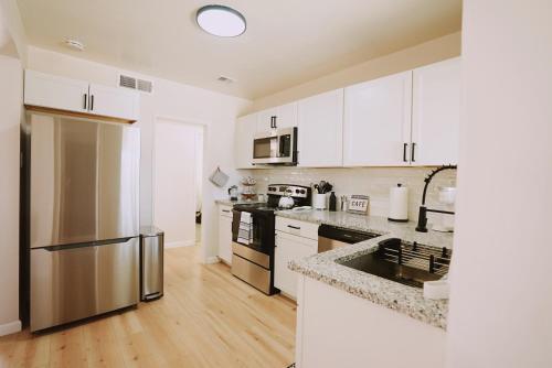 a kitchen with white cabinets and stainless steel appliances at Centrally Located! Remodeled! Huge Backyard! The White House in Albuquerque
