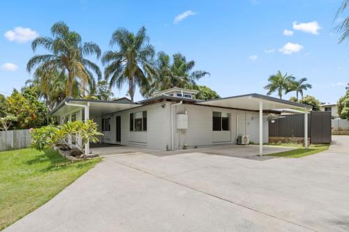 a white house with palm trees in the background at Small Groups and Families Stylish 3Beds near mall in Marsden