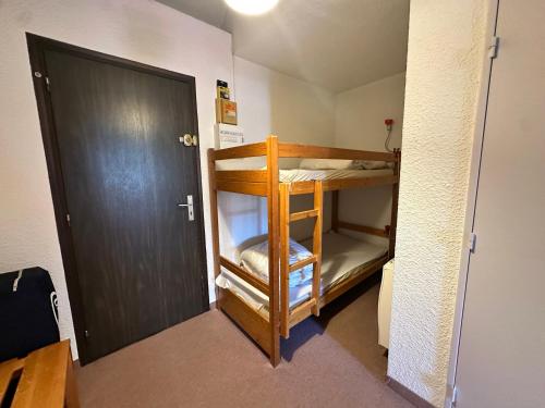 Cette chambre dispose de lits superposés et d'une porte. dans l'établissement Studio cabine avec balcon sud, proche centre, pistes de luge et piscine - FR-1-515-109, à Villard-de-Lans
