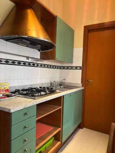 a kitchen with green cabinets and a stove top oven at Wonderful Como in Como