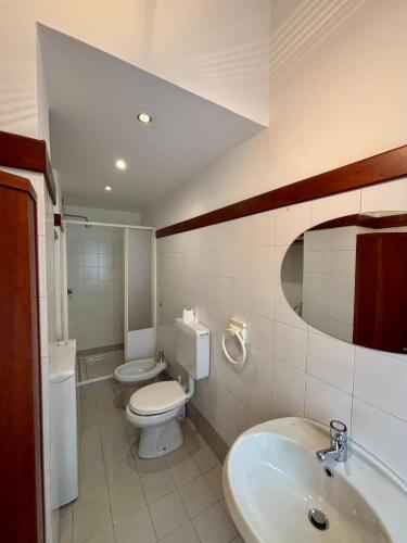 a bathroom with a sink and a toilet and a mirror at Wonderful Como in Como