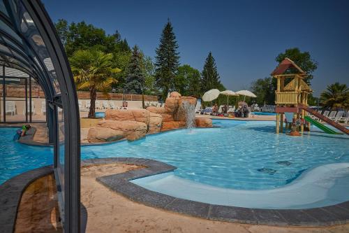 a large pool with a water slide in a resort at Camping Le Chêne Gris in Pommeuse