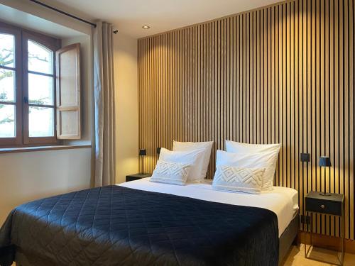 a bedroom with a large bed with a blue blanket at Domaine de Cazal - Chambres d'Hôtes avec piscine au cœur de 26 hectares de nature préservée in Saint-Cyprien