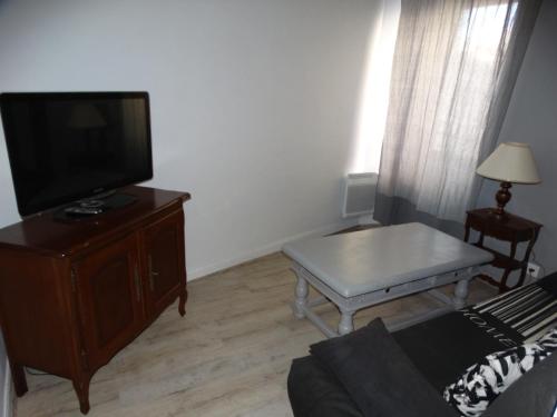 a living room with a couch and a tv and a table at L'estaou in Lavoûte-Chilhac
