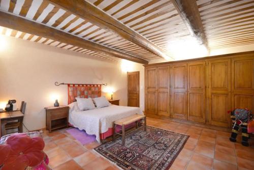 - une chambre avec un lit dans une pièce dotée d'armoires en bois dans l'établissement Mas de l'OLIVE piscine plancha 4 chambres Provence, à Châteaurenard