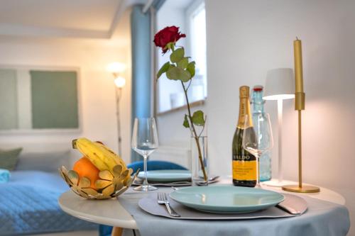 a table with a bottle of wine and a bowl of fruit at Ruhig Top mod Studio Appartement,privater Eingang in Oberhaching