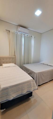 a bedroom with two beds and a window at White River in Boa Vista