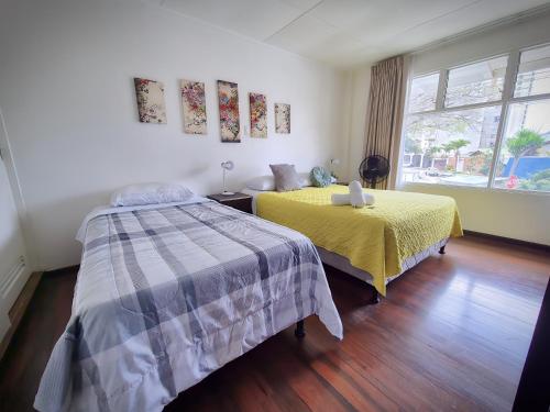 a bedroom with two beds and a window at Casa Jardin del Mango in San José