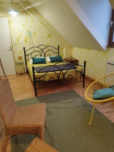 - une chambre avec un lit doté d'oreillers et de chaises bleus dans l'établissement Gite La Trotiniere, à Luynes