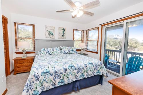 a bedroom with a bed and a balcony at Oceanside, Close to Beach, Hot Tub- OS5H, Long Beach Day in Corolla