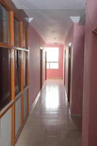 a hallway of a building with pink walls and a long hallway at Hotel Prashant International in Gandhidham