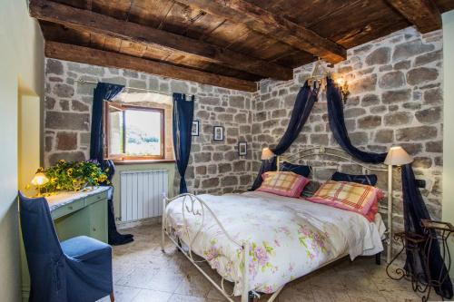 a bedroom with a bed and a stone wall at Arcera AGRITURISMO in Piana di Forcella
