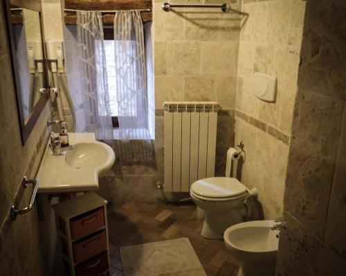 a bathroom with a toilet and a sink at Arcera AGRITURISMO in Piana di Forcella