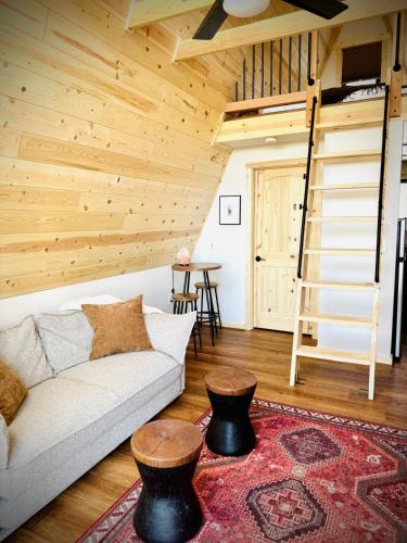 a living room with a couch and a ladder at The Scout a cozy mountain cabin with million dollar view in Ironton