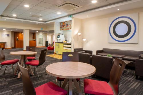 a waiting room with two tables and chairs at Holiday Inn Cambridge by IHG in Cambridge