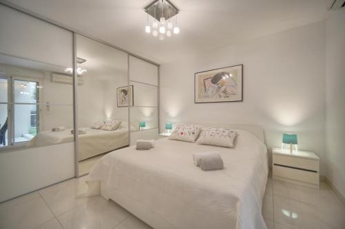 - une chambre blanche avec un grand lit et une salle de bains dans l'établissement 2 Pieces moderne avec terrasse A1B263, à Cannes
