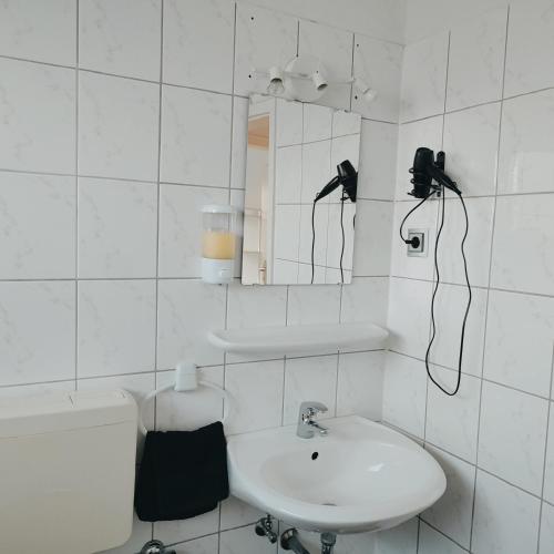 a white bathroom with a sink and a mirror at Monteur-Ferien-Messewohnung Mettmann 6 Personen 2 OG in Mettmann