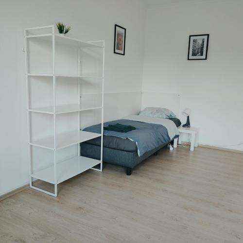 a bedroom with a white book shelf next to a bed at Monteur-Ferien-Messewohnung Mettmann 6 Personen 2 OG in Mettmann