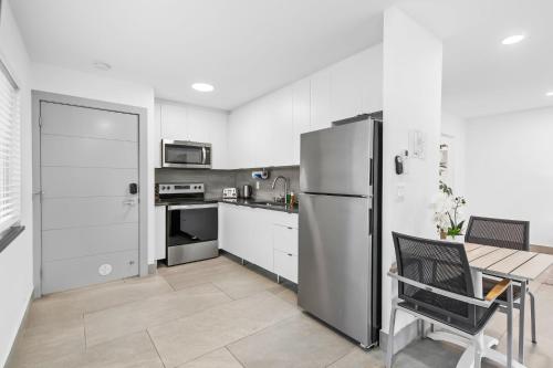 a kitchen with a stainless steel refrigerator and a table at Unique Retreat - Unit B: Homey First-Floor Haven in Deerfield Beach