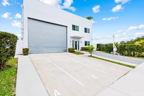 a white house with a large garage at Unique Retreat - Unit B: Homey First-Floor Haven in Deerfield Beach