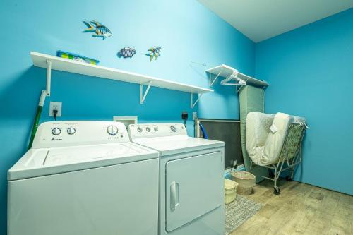 a washing machine in a blue room with a chair at Boss's Playhouse in Kill Devil Hills