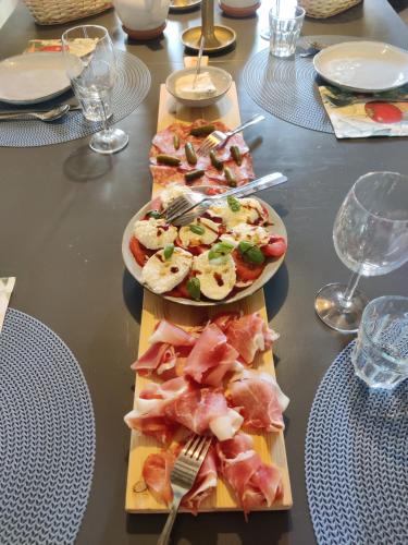 two plates of food on a table with plates of food at Chambres d'hôtes / B&B Chez Mon Rêve in Éguzon-Chantôme