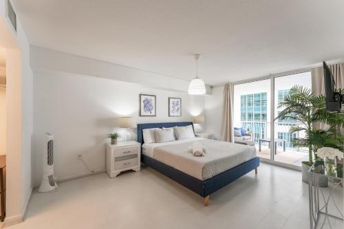 una camera con un letto blu e una grande finestra di Lux Brickell Bay Condo City Views & Prime Location a Miami