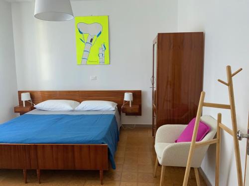 a bedroom with a bed and a chair at Palma 12 in Lignano Sabbiadoro