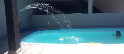 a person in a swimming pool with a water fountain at Casa de Praia in Pontal do Paraná