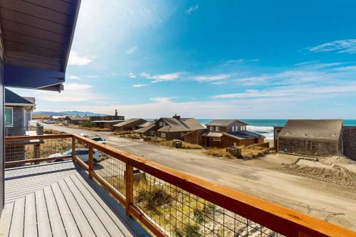 a balcony with a view of the ocean and houses at The Kiwanda Surf House in Pacific City
