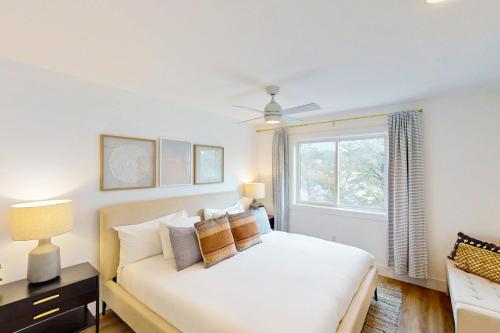 a white bedroom with a bed and a window at The Kiwanda Surf House in Pacific City