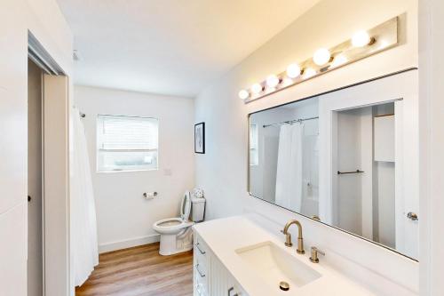 a white bathroom with a sink and a toilet at The Kiwanda Surf House in Pacific City